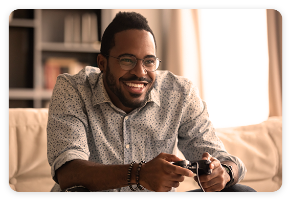 Tealium CDP for Gaming - African American man playing video game and smiling
